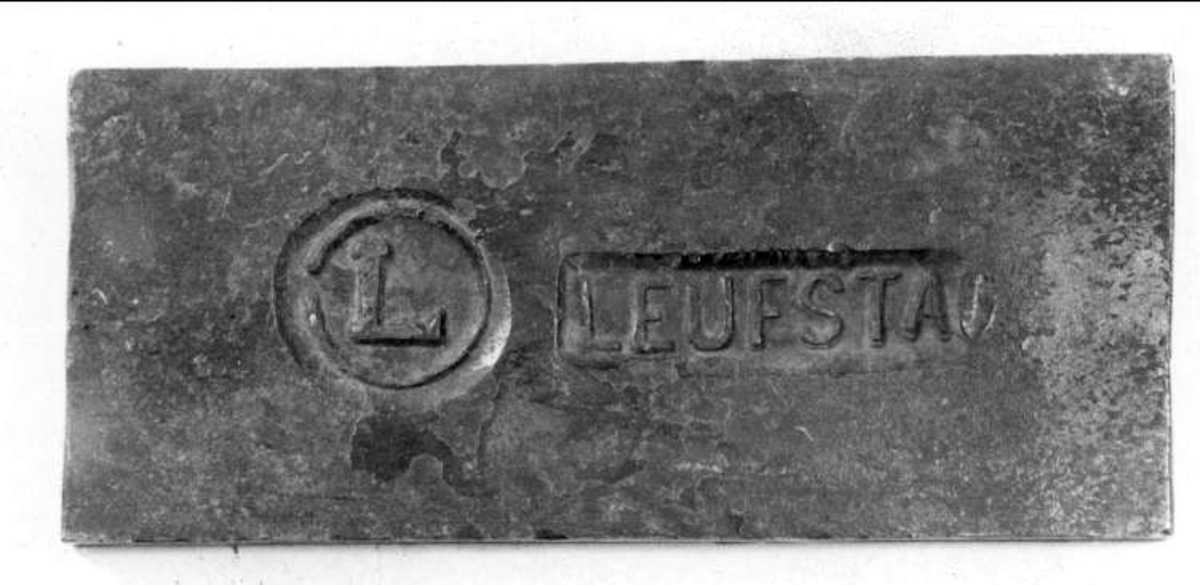 Rektangulärt järnstycke, bit av stångjärn, med Leufstabruks bruksstämpel, ett L, inom en ring och LEUFSTA.