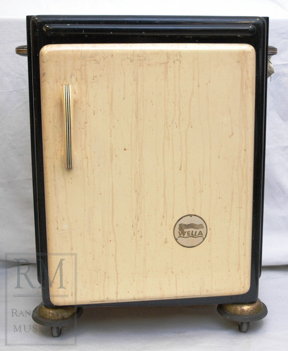 Permanentapparat med skap under og utstyr til kaldpermanent i brun kasse.