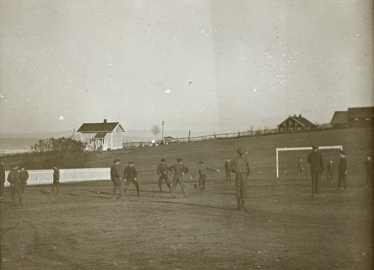 Bilder fra dagliglivet på Toftes Gave, Nedre Sund, Helgøya. Gutta spiller fotball på idrettsplassen.
