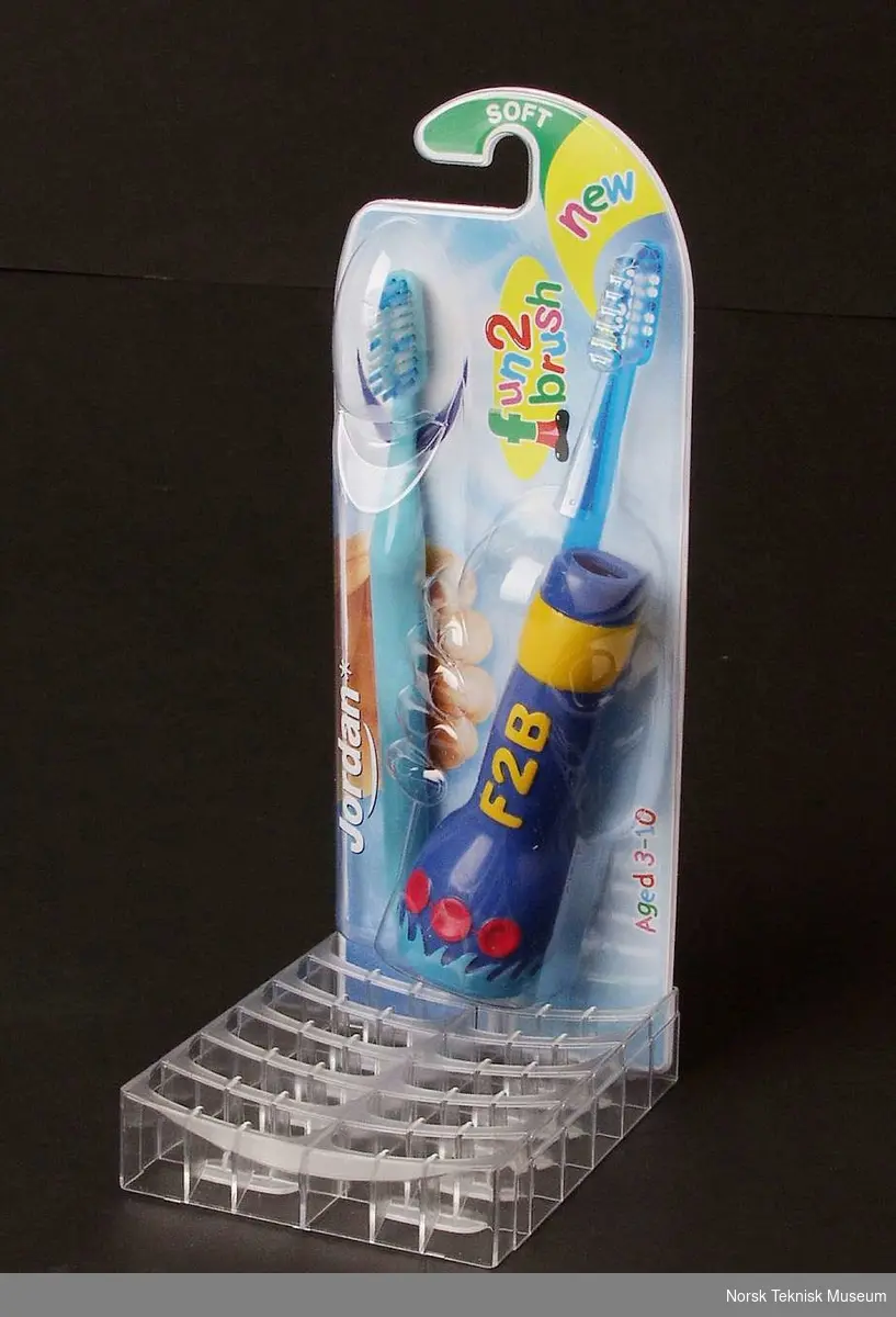 Tannbørste med holder i emballasje på stativ