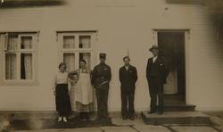 Familiegruppe foran hus