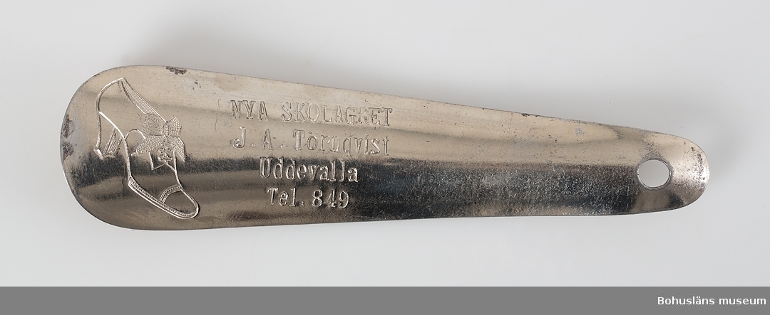 Skohorn av blankk metall med ingjuten text:
 J. A. Törnqvist Uddevalla Tel.849