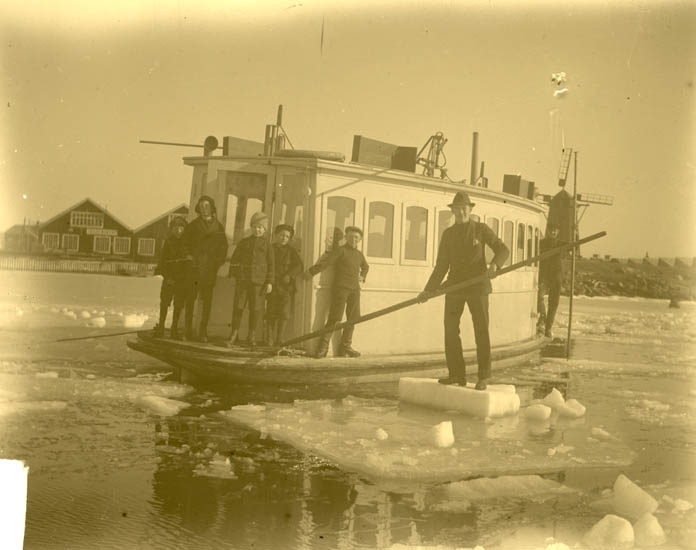 Män tar sig fram bland isflaken med färjan mellan Koön och Marstrand