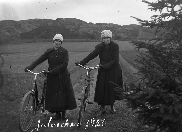 "Julveckan 1920. Klara, Justina Benjaminsson" ute med sina cyklar någonstans i Kville-trakten i Bohuslän