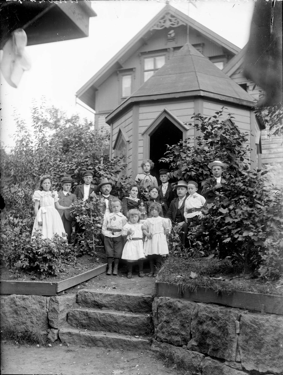 Familiene Krohn og skredder Larsen i hagepaviljongen i Peder Clausens gate 19