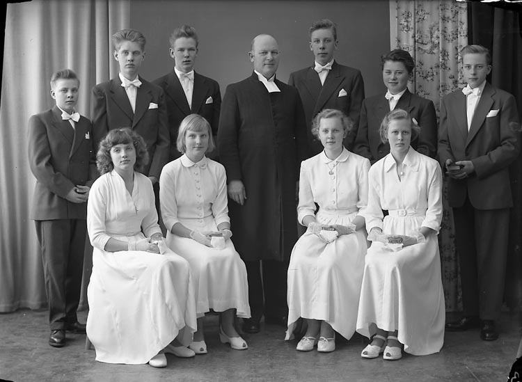 Enligt fotografens notering: "Pastor Hjalmarsson. Norums Konfirmander Stenungsund. D. 29 mars 1954".