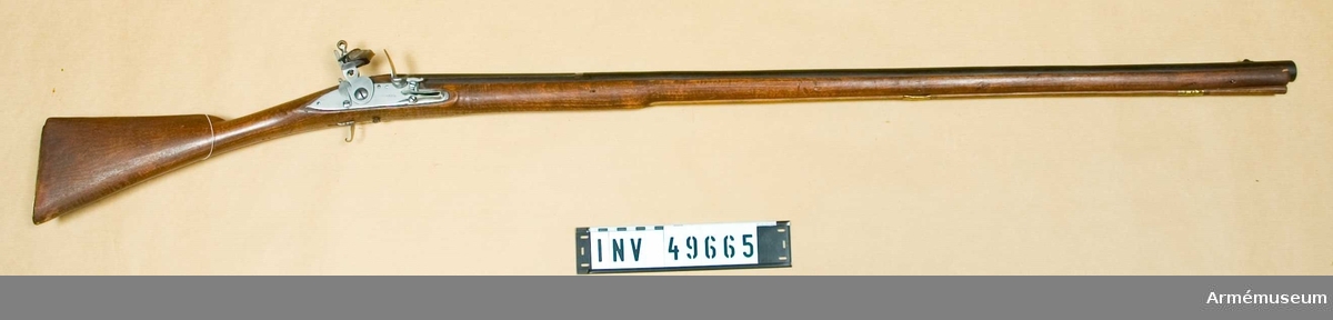 Grupp E XIV.
Loppets relativa längd 56,2 kal. Afrikanskt gevär med flintlås. Varbygeln fattas. På pipan och kolven finns siffrorna 233.