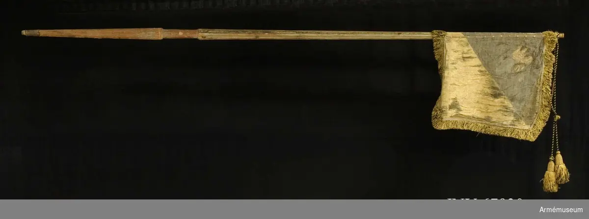Duk:
Enkel, tillverkad av damast, gul och svart, ganska trasig, skarvad nedtill horisontellt. 

Dekor:
Diagonalt delad i två fält, det övre, inre svart, det nedre, yttre gult; i inre hörnet målat omvänt lika på båda sidor ett upprätt lejon, övre halvan i brunskuggat guld,nedre i mörkgrått, följt av två stjärnor i svartskuggat silver (Västergötlands vapen). 

Frans:
Dubbel, i svart och gult silke, fäst vid stången med tre rader tennlickor på svarta och gula band. 

Stång:
Tillverkad av trä, kannelerad; holk av mässing; doppsko av läder, fastsydd.