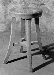 Stol, rund sittyta utan ryggstöd med fyra ben någotutsvängda,
sammanbundna av ett korskryss.