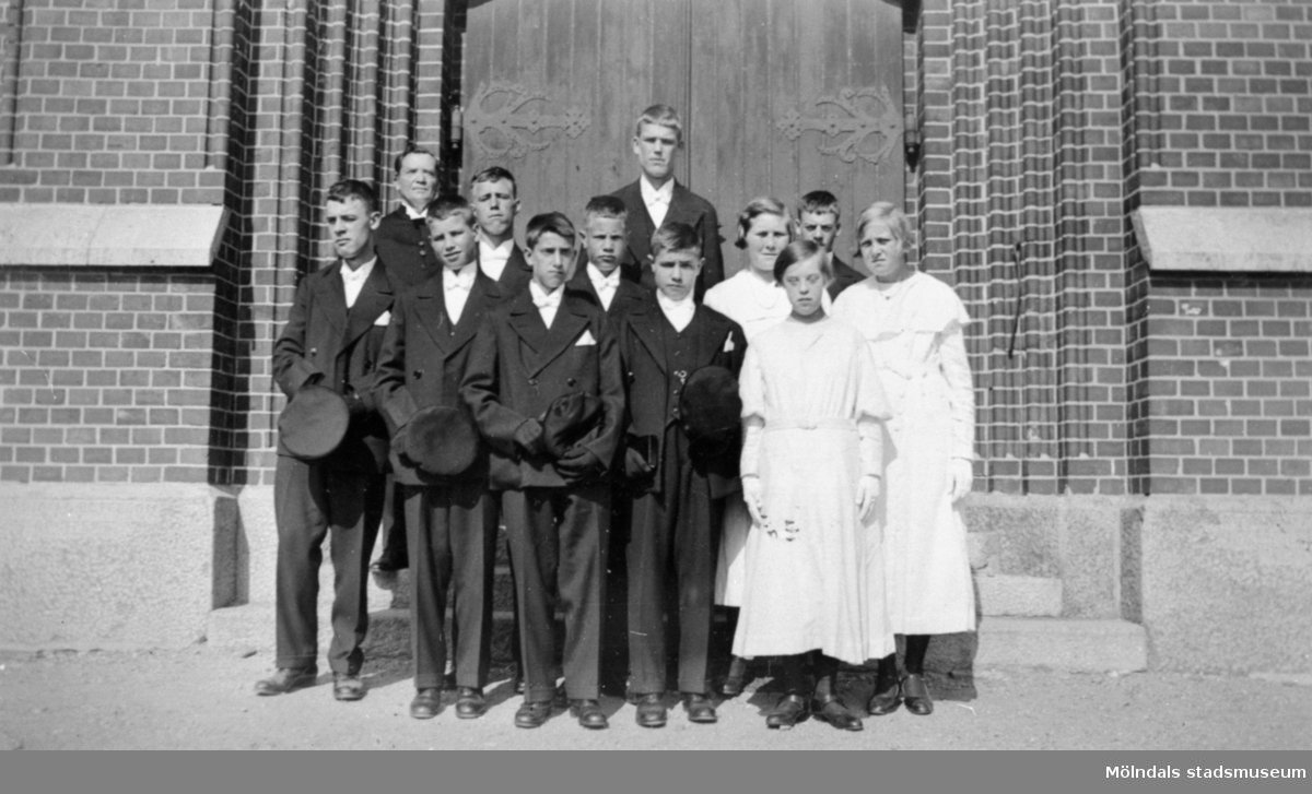En konfirmandgrupp från Stretereds skolhem fotograferade framför porten till Fässbergs kyrka. Årtal okänt.