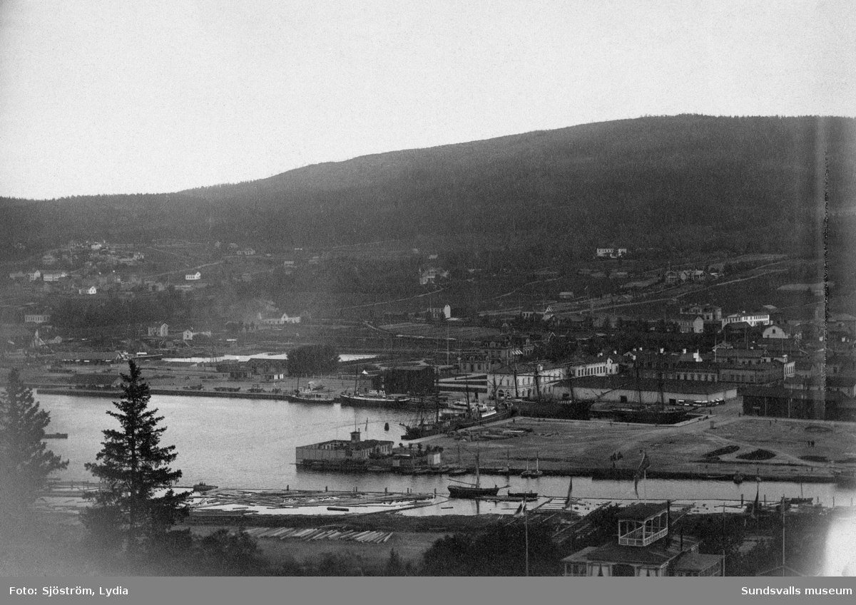 Vy tagen från Norra Berget mot hamnen med kallbadhuset byggt 1876 i mitten av bilden.
Bildtext i album "Sundsvalls hamnområde med badhuset".