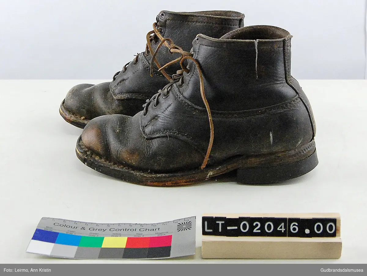 Ett par sko i lær, flate såler som er naglet og sydd til skoene, med knytting. 
