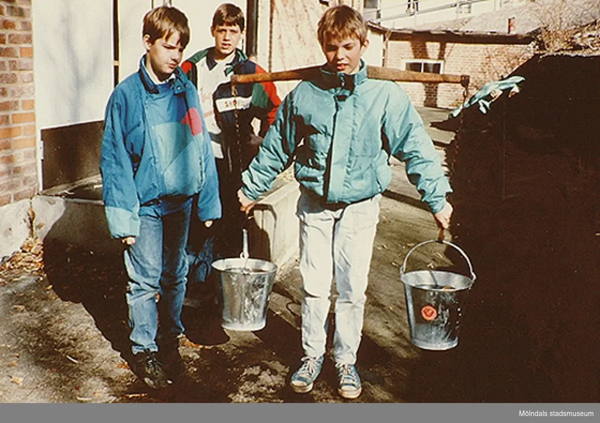 Elever som prövar att bära ok med vatten. Mölndals museum, okänt årtal.