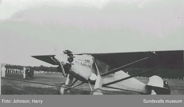 Text på baksidan: "Lindbergs flugskep Wi tog detta här kort i sommar. Harry Johnson". Charles Lindbergh (1902 - 1974) genomförde 1927 den första ensamflygningen över Atlanten med sitt plan "Spirit of St. Louis".