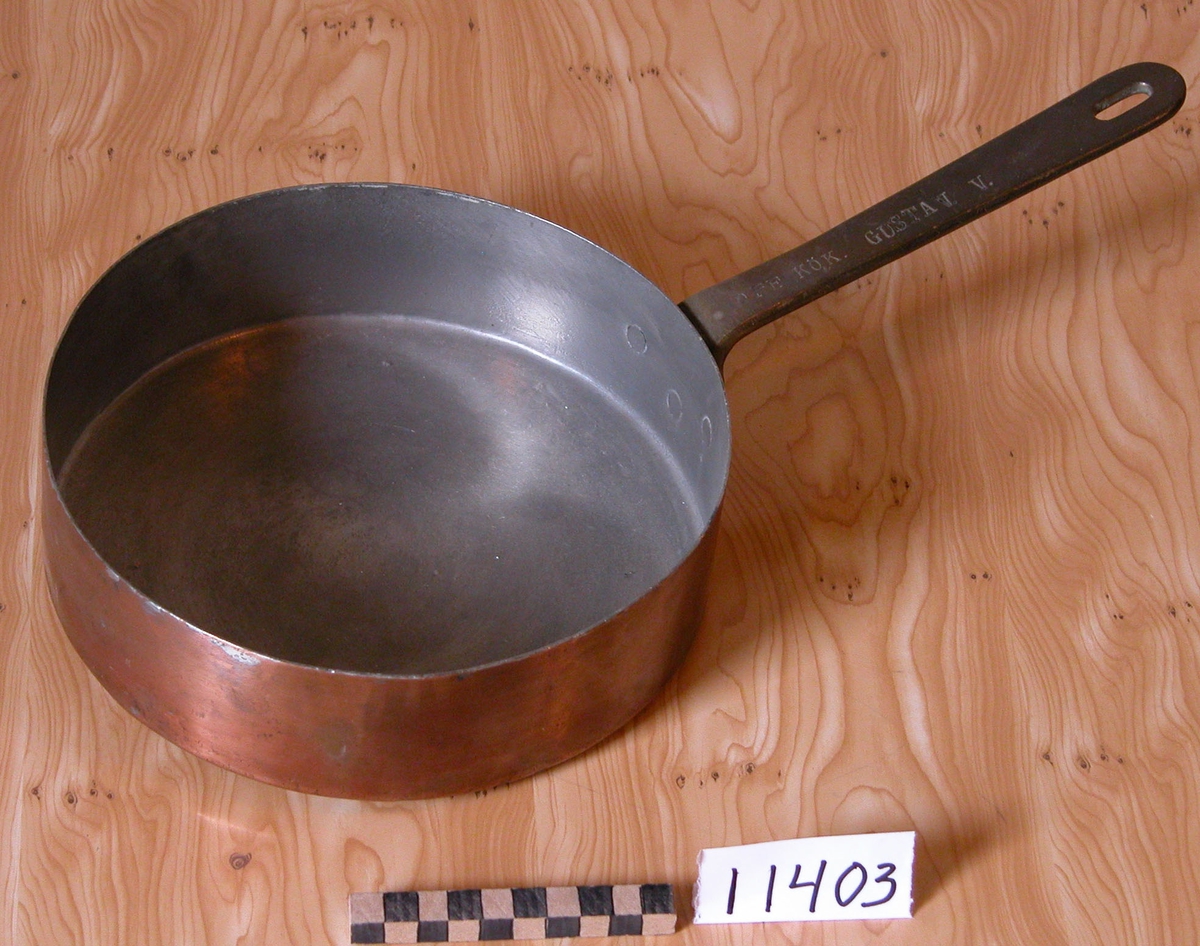 Stekplåt av koppar med handtag.
Märkning: Off.kök Gustav V samt Skultuna 1607  2 L och krona.
Från 1920-talet.