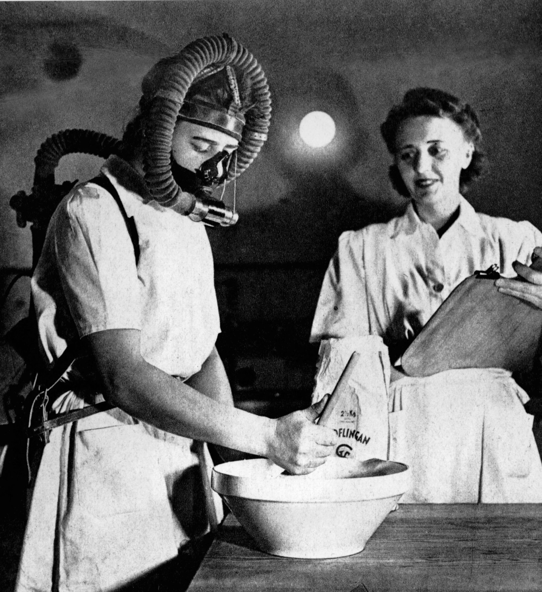 Bo bättre-utställningen 1945
Interiör. Kvinna med mask vid bytta, samt kvinna bredvid som mäter. Bo bättre-utställningen 1945, Bostadsvaneundersökning.