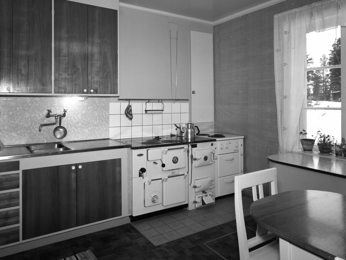 Timmerstuga, Snickarens hus
Interiör av kök, diskbänk och spis med del av matbord i förgrunden