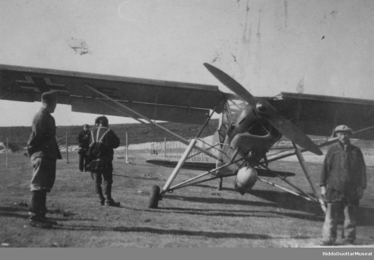 Njeallje dievddu soadjegirdi guoras, Fieseler Storch girdi.
Fire menn rundt et propellfly av type Fieseler Storch.