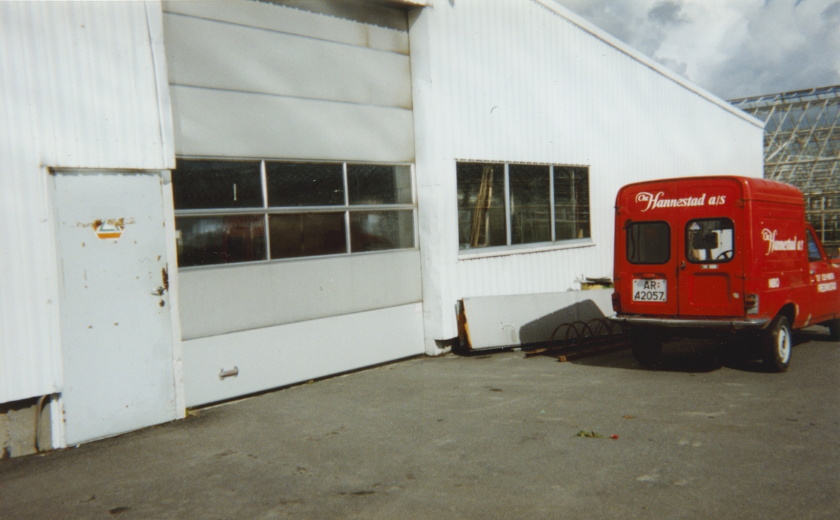 Rød varebil med Chr. Hannestad sin logo utenfor driftsbygning ved Lia gartneri.
