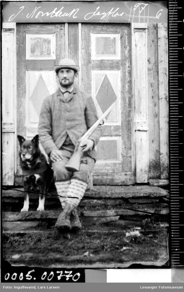 Portrett av mann med gevær og hund.