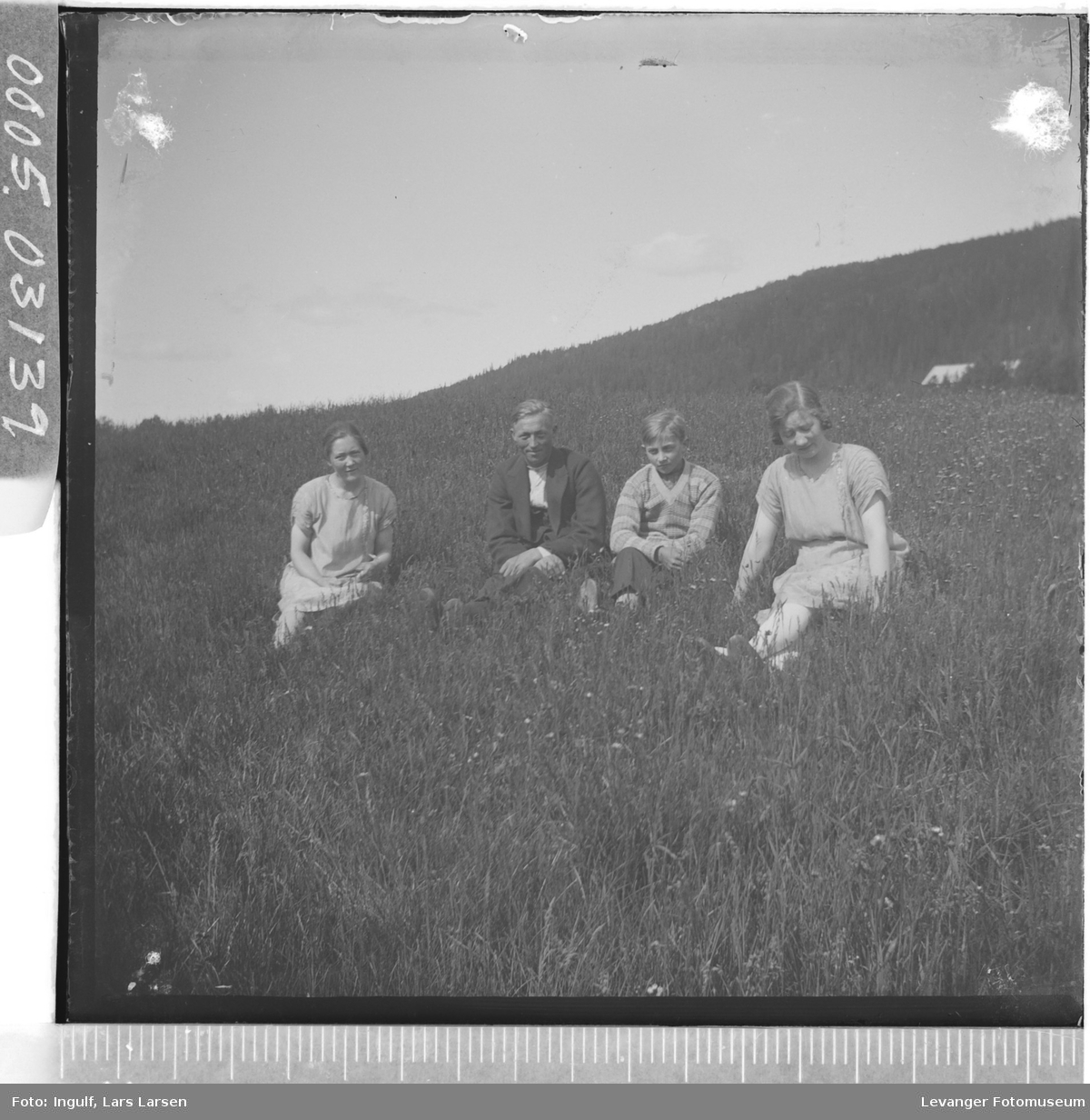 Gruppebilde av to kvinner og to menn sittende i gresset.