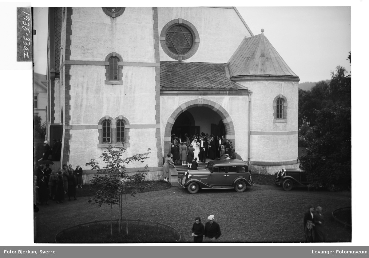 Brudeparet Martens foran Levanger Kirke. Bilen foran trappa er en Chevrolet 1934-modell.