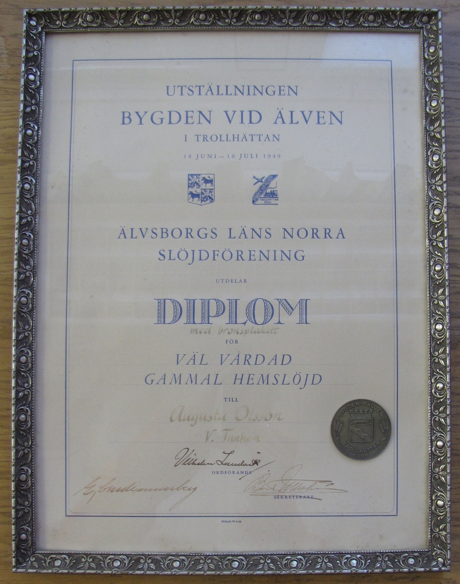 Inramat diplom utställt av Älvsborgs läns norra slöjdförening till Augusta Olofsson. (På diplom och på schalar står det dock Augusta Olsson).



Augusta Olofsson (1867-05-19 - 1955-12-01) ställde ut 6 schalar på utställningen Bygden vid älven i Trollhättan 18/6 - 10/7 1949. Hon erhöll ett diplom med bronsplakett med motiveringen: Väl vårdad gammal hemslöjd. Utställningen blev en stor folkfest med specialprogram med invigning, Nordens Dag, Hembygdens Dag, Jordbrukets och Hemslöjdens Dag, Kooperationens Dag, Kristen Samling, Barnens Dag, Hantverkets Dag och Försvarets Dag. Dåtidens kändisar framträdde, så som Gösta Knutsson, Västgöta-Bengtsson, Harry Brandelius, Bertil Boo, Gunnar Turesson och Lennart Hyland.



Hon var gift med Karl Olofsson (1867-05-18 - 1957 -07-13). De fick 4 barn vilka bodde kvar i familjehemmet hela livet.