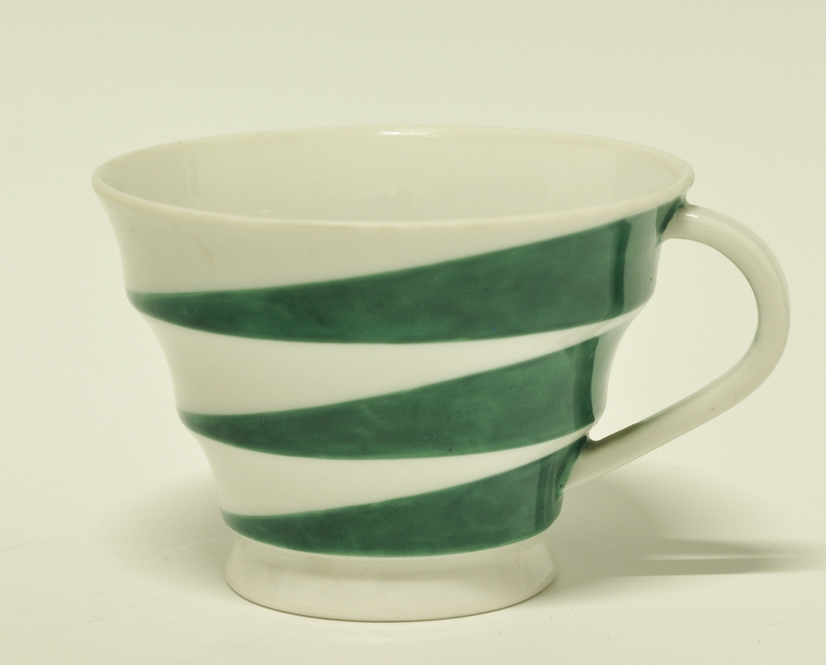 Kopp av porselen. Samme modell (nr. 395) som BM.1967:478a. Hvit glasur med diagonale grønne felt på de tre konkave ledd. 
Modell: 395.4
Dekor: 5794