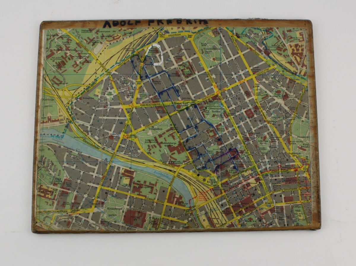 Karta över del av Stockholm, uppklistrad på plywoodskiva. Ena sidan visar Norrmalm, den andra sidan Djurgården och Ladugårdsgärde. Färdvägen för tömningen av brevlådor är inritad med kulspetspenna. Märkt "Adolf Fredrik" på kartsidan visande Norrmalm.