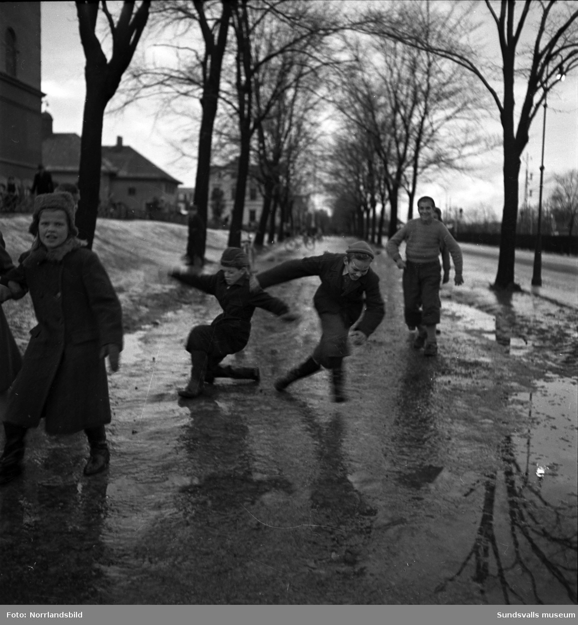 Skolbarn halkar fram på Södra Järnvägsgatan invid GA-skolan en snöfri decemberdag 1949.