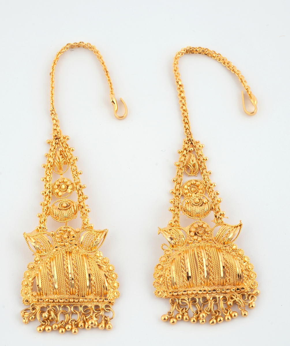 Gullfargede smykker til brudedrakt. Består av 9 armringer, et par øreheng, 2 halssmykker og 2 anheng = ukjent bruk