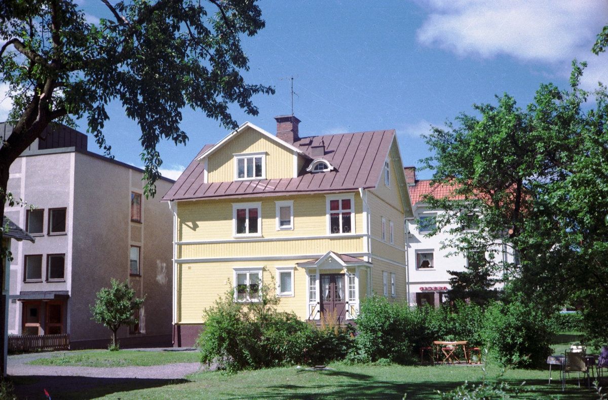 En gul trävilla på Linnégatan i Huskvarna. Mitt emot ligger Gisebo-affären och till vänster Handelsbanken.