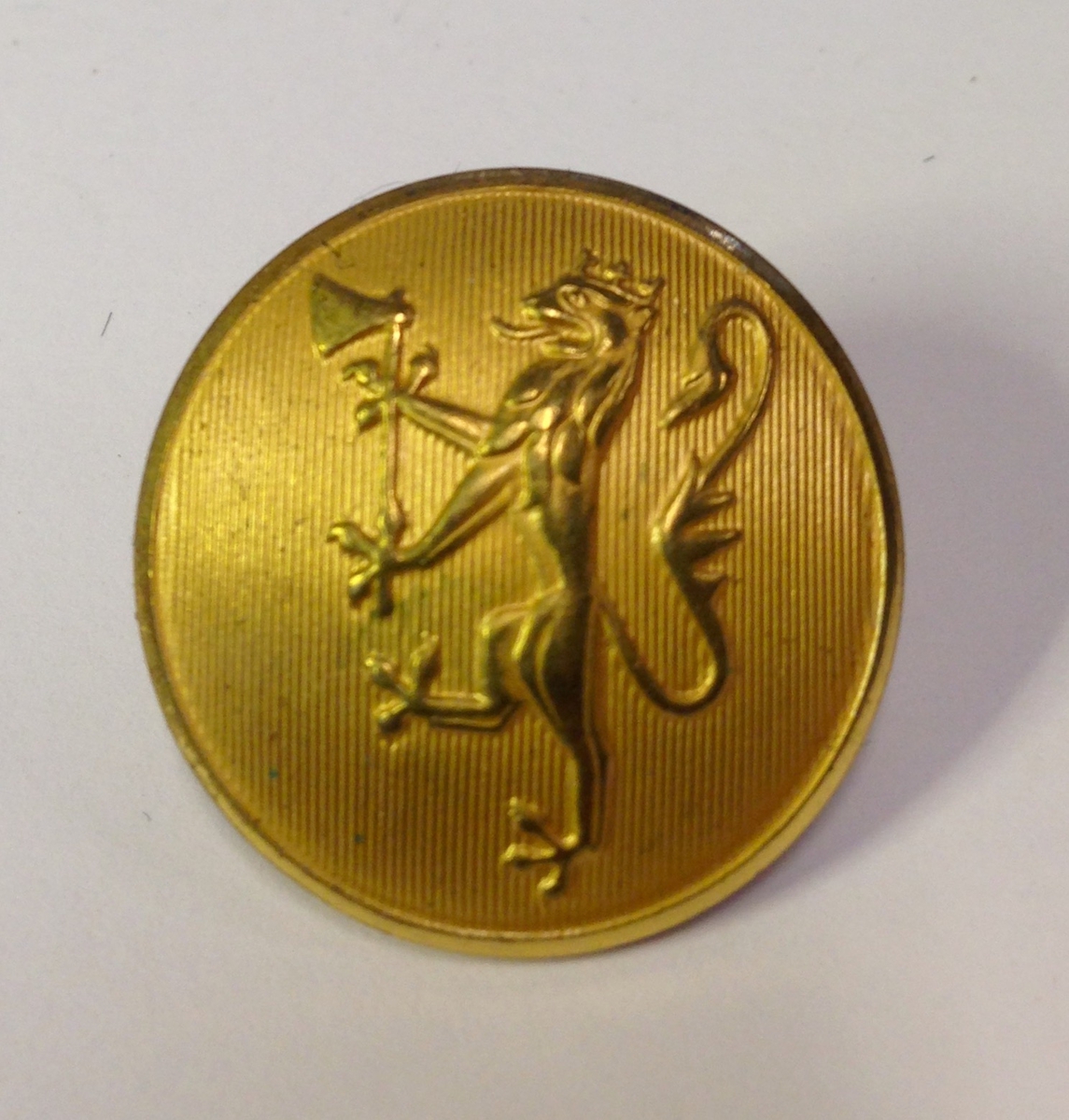 29 store og 15 små gullfargete metallknapper med løvemotiv.