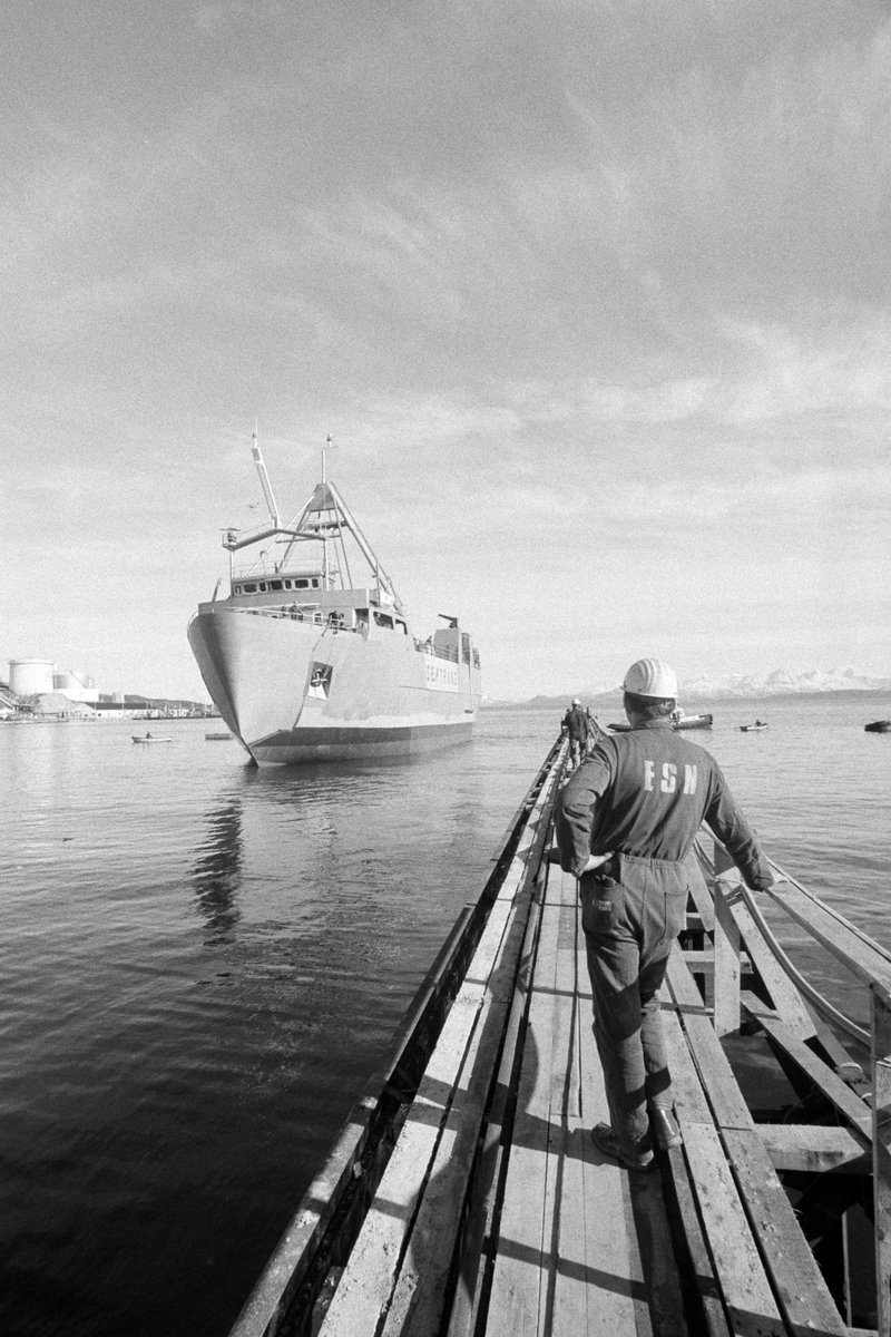 Sjøsatt fartøy utenfor ESN-verkstedet i Samasjøen. Arbeider i forgrunnen.