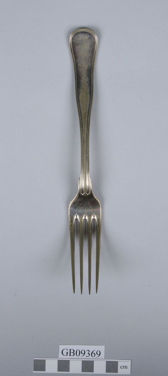 Stor gaffel med fire tinner. Dobbelkant rundt skaftet. 4 stempler på baksiden