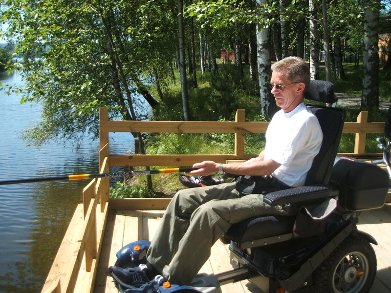 Foto av person i rullestol som  fisker.