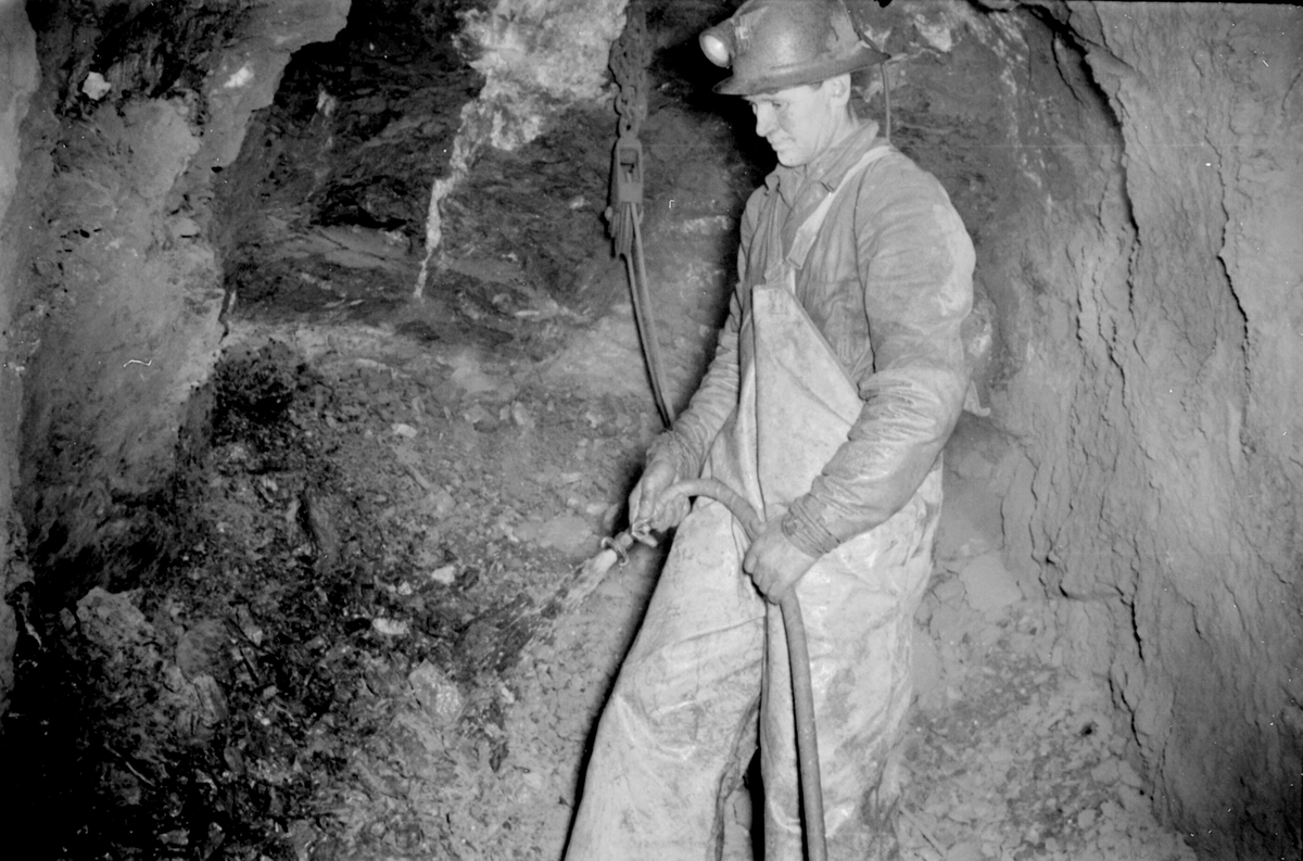 Farlige forhold og farlige arbeidsmetoder i gruva. Gruvearbeider i arbeid.