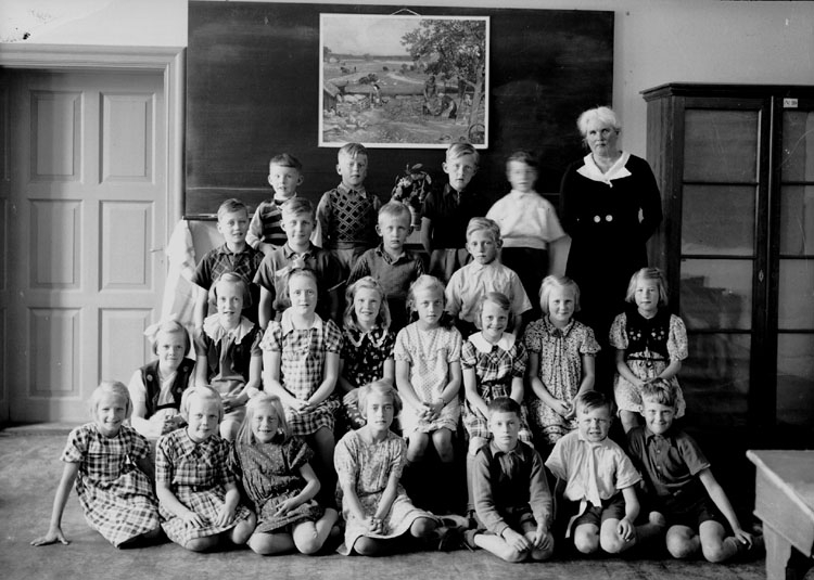 Vasaskolan, klassrumsinteriör, 12 flickor, 11 pojkar och lärarinna fröken Hildur Johansson.
Klass 2, sal 8.