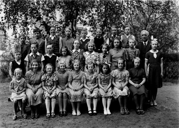 Rynninge skola, 27 skolbarn med lärare Sam. Nystedt på skolgården.
Skolbyggnad i bakgrunden.