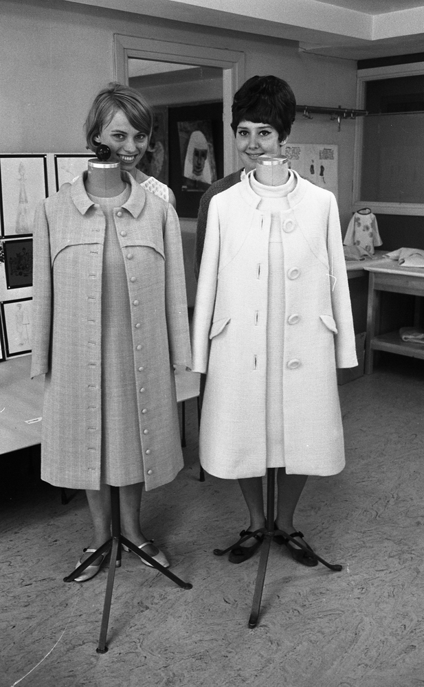 Humlan avslutning, Tjuvgodset, Thomas Nordahl 2 juni 1967

Två unga kvinnor som går en sömmerskeutbildning visar sina verk på två provdockor som är placerade framför dem. Den ena kappan är beige med en beige klänning inunder. Den andra kappan är vit med en vit klänning inunder. Båda kvinnorna ler.