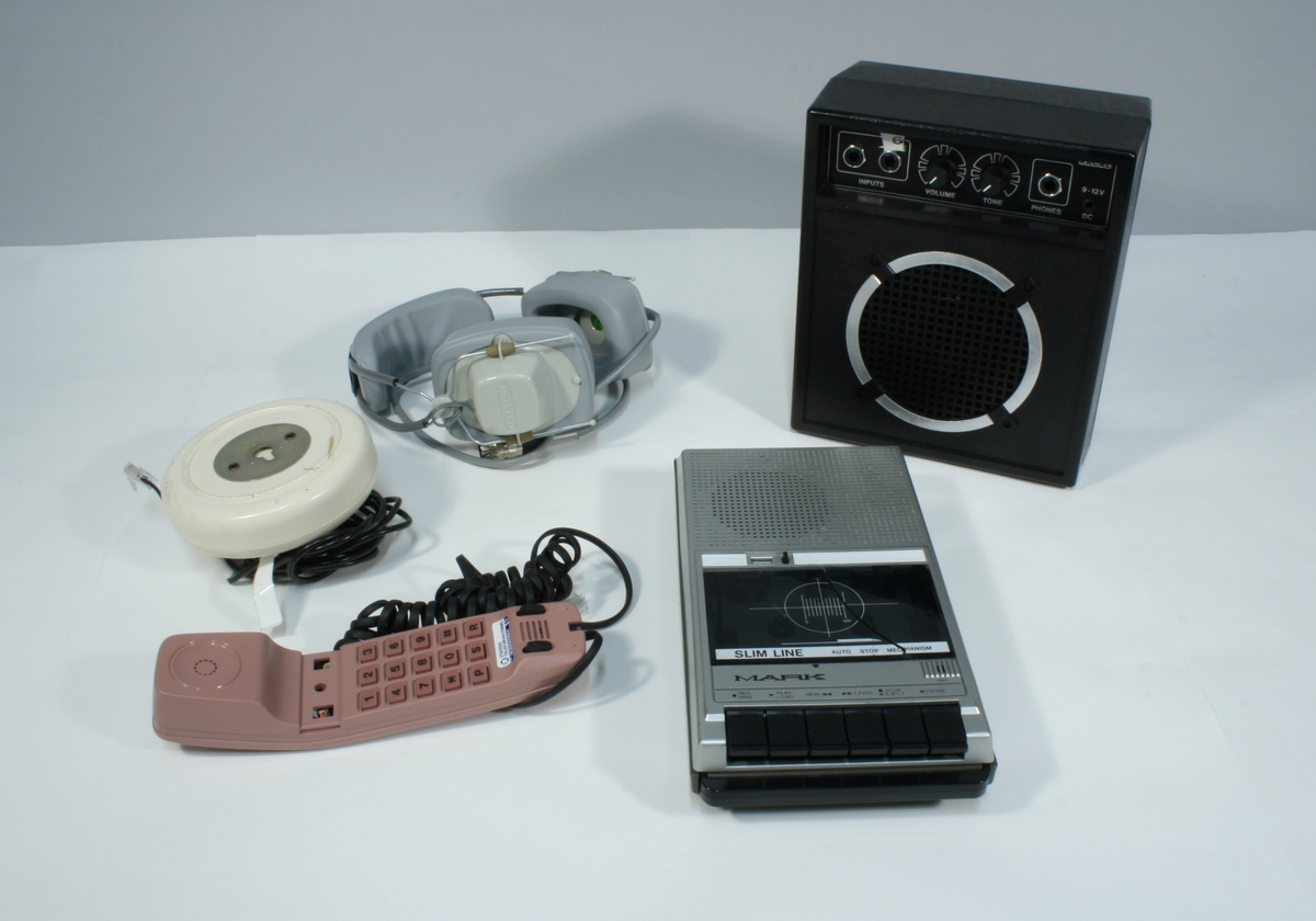 Kofferten inneholder flere mindre esker med 4 Astrolite hodetelefoner og et mindre headset til båndopptaker. En mengde kabler. En høytaler. En kassettspiller. En telefon med ledning.