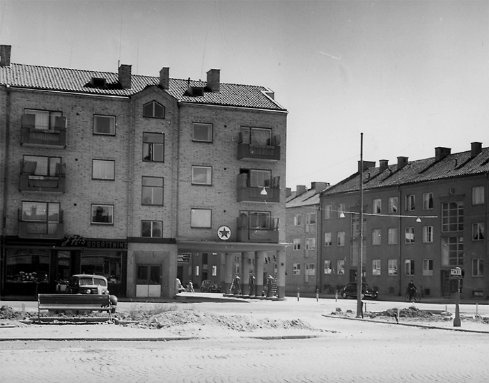Bostadshus. 
Caltex bensinstation. Gumaeliusplan/Bromsplan (hette Gumaeliusplan fram till 1969, bytte då namn till Bromsplan pga förväxlingar med Gumaeliusskolan på Väster). 
Bromsgatan till höger i bild.