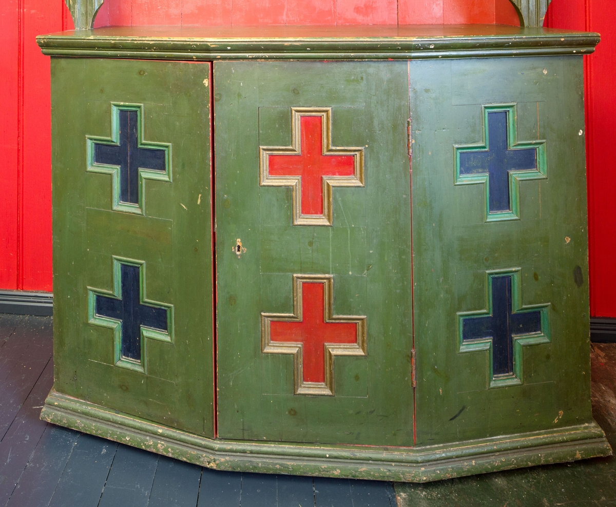 I dør og sider på underskap kryss som er malt.  2 Rosemalte skyvedører m/tekst på skap  øverst, 2 hyller og underskap m/1 hylle. Lite skap i høyre side. Skuff til bestikk.