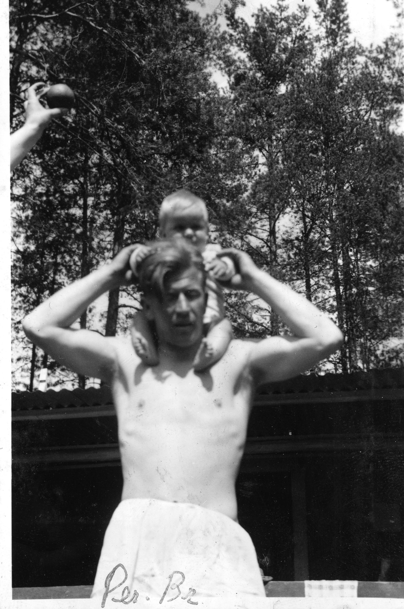 Infant Per on the shoulders of Birger Ruud