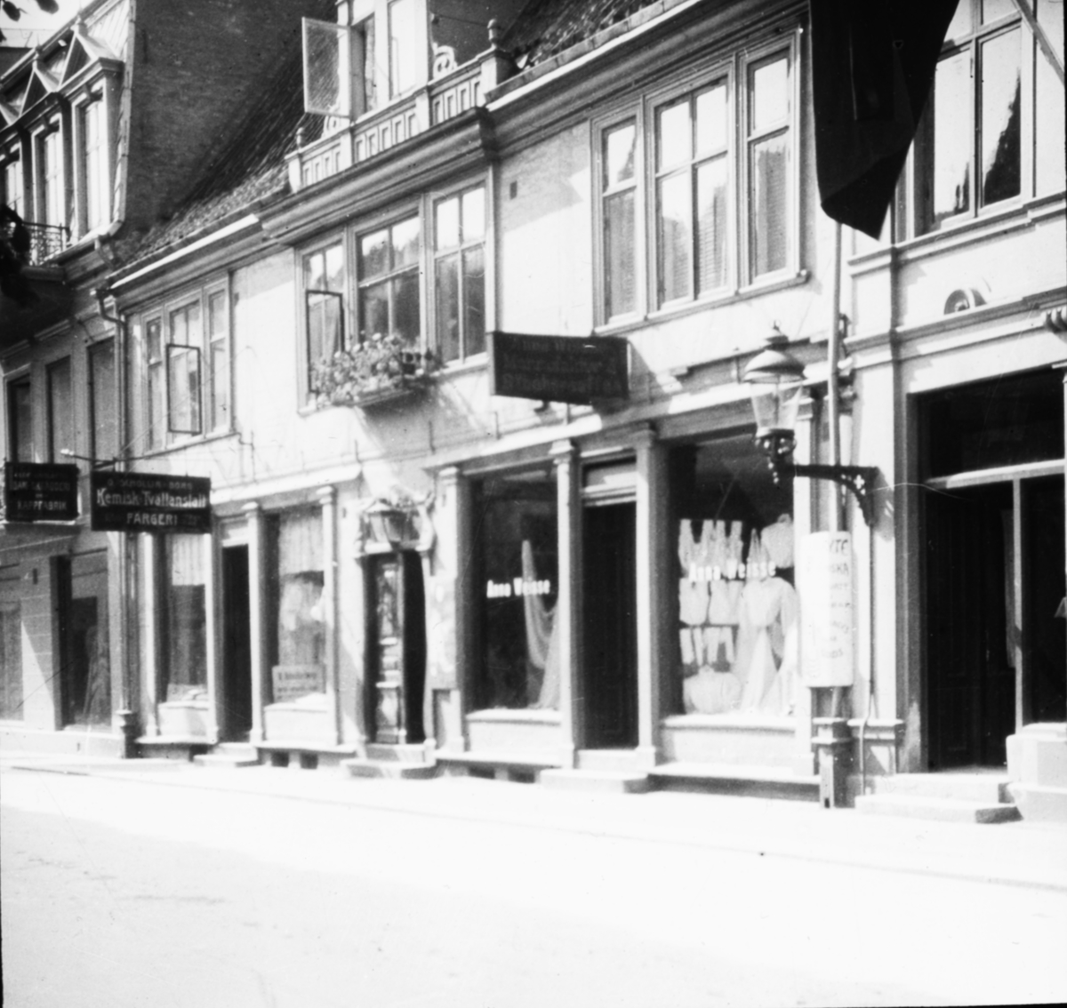 Skioptikonbild med motiv från gata i Helsingborg. Kemisk tvättanstalt, färgeri. Norra Storgatan 9 som efter en restaurering på 1920-talet går under namnet Gamlegård.
Bilden har förvarats i kartong märkt: Helsingborg 8. 1908