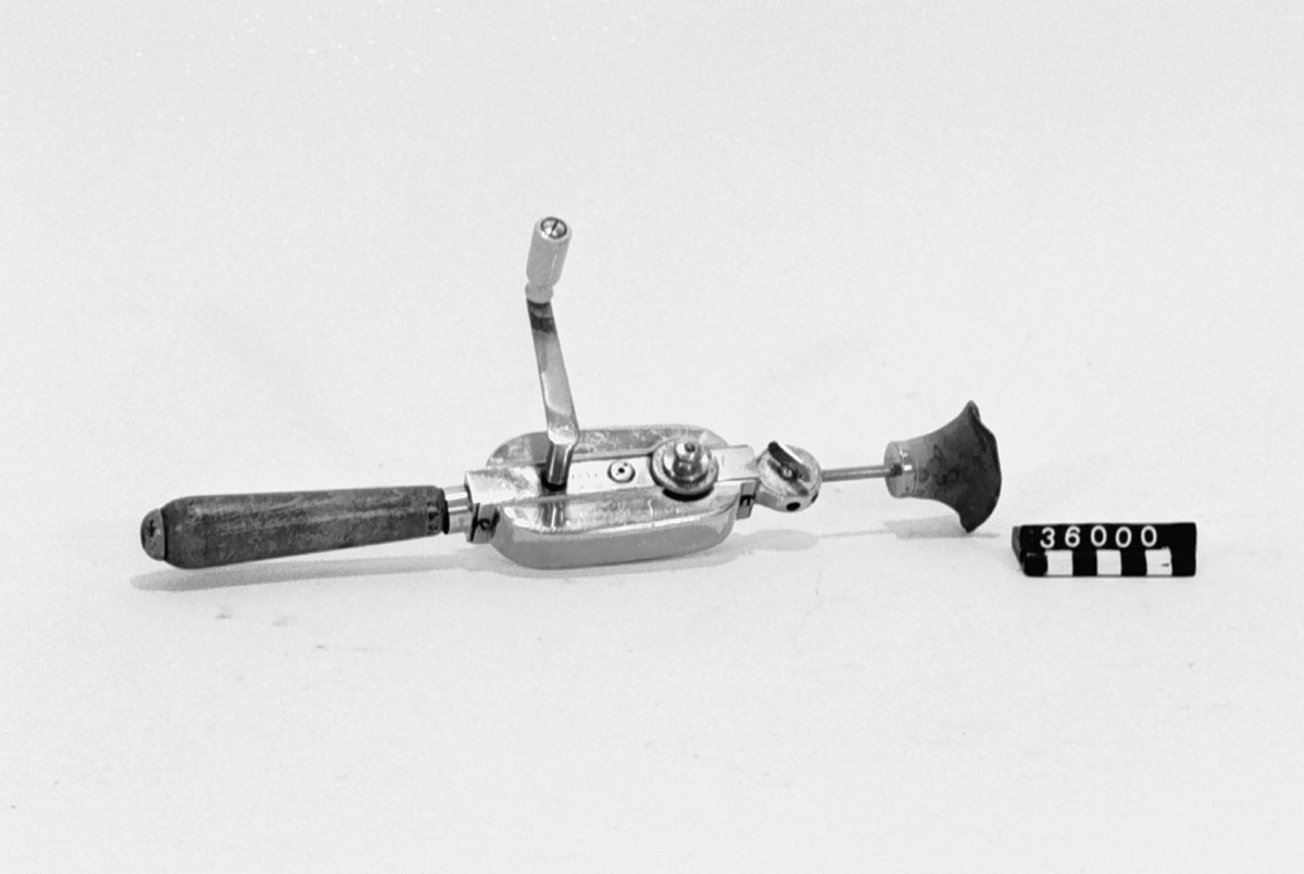 Dr Johanssons Auto-Vibrator. Förnicklat metallhölje med trähandtag och munstycke av kautschuk, som försättes i vibration med vev och kan placeras i 6 olika lägen. Kautschuken har vid inv.1996 deformerats.