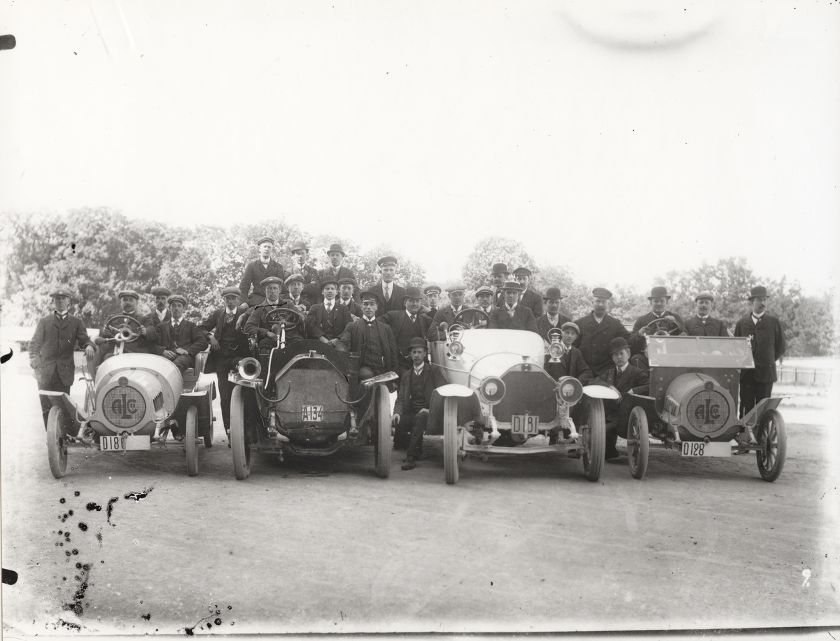 Elever vid Eric Lundviks körskola, samlade kring fyra automobiler vid utkanten av Östermalm, omkring 1915-1920.