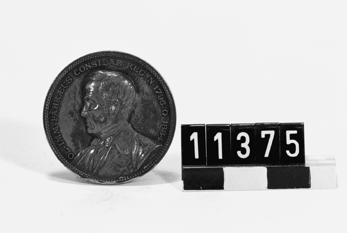 Medalj i silver över Olof Immanuel Fåhraeus, f. 1796, d. 1884. Tjocklek 3 mm. Slagen av Vetenskapsakademien år 1889. Åtsidan: Porträtt i lågrelief av O. I. Fåhraeus vänster profil med text runtom: "OL. IMM. FÅHRAEUS CONSILAR. REG. N. 1796 O. 1884". Frånsidan: Text: REIPUBLICAE# LABORARVIT# SCIENTIAE# VACAVIT" omgivet av ekkvist och lagerkvist samt text runtom: "SOCIO SUO MERITISSIMO REG. ACAD. SC. SUEC. MDCCCLXXXIX". Signerad: L.A.