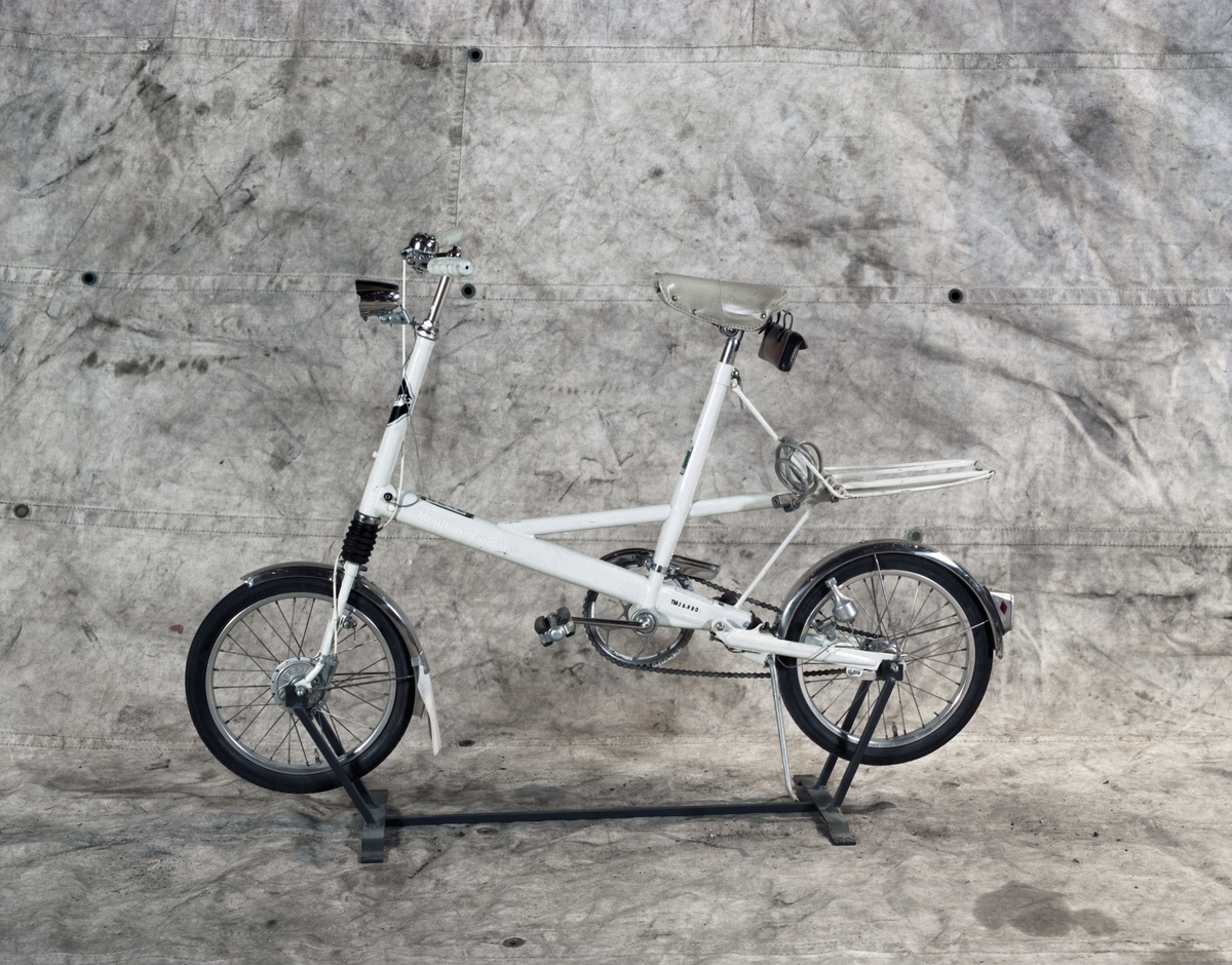 Låghjuling cykel av stål, "Moulton Standard". Minicykel med fjädring fram och bak. Hjuldimension 16 tum. Rostfria skärmar. Trumbroms fram.
Tillbehör: Verktygsväska och wirelås.