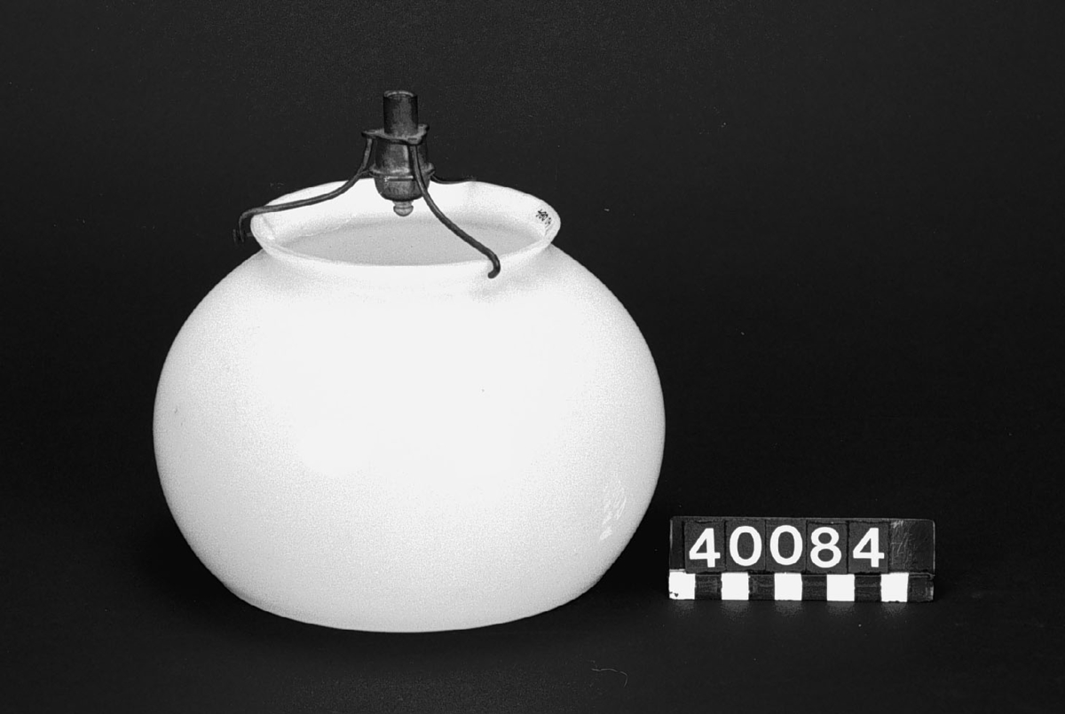 Lampkupa med gasbrännare. Kupa är tillverkad av porslin, till formen rund och brännaren är av mässing.